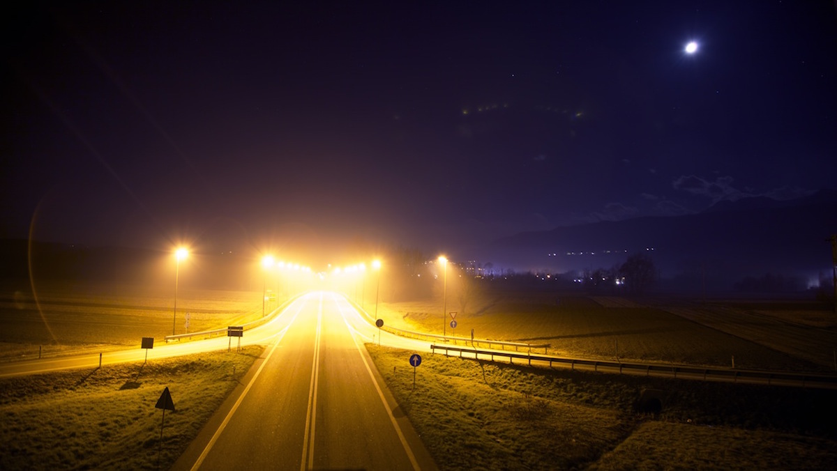 Picture of a road illuminated by street lights late at night